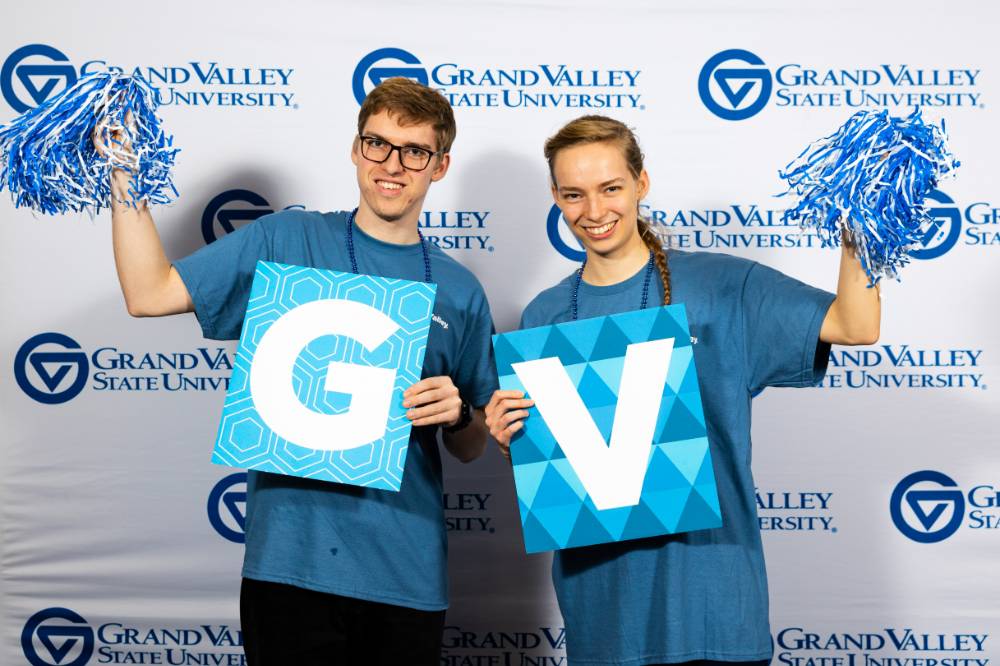 individuals smiling with gv sign and poms